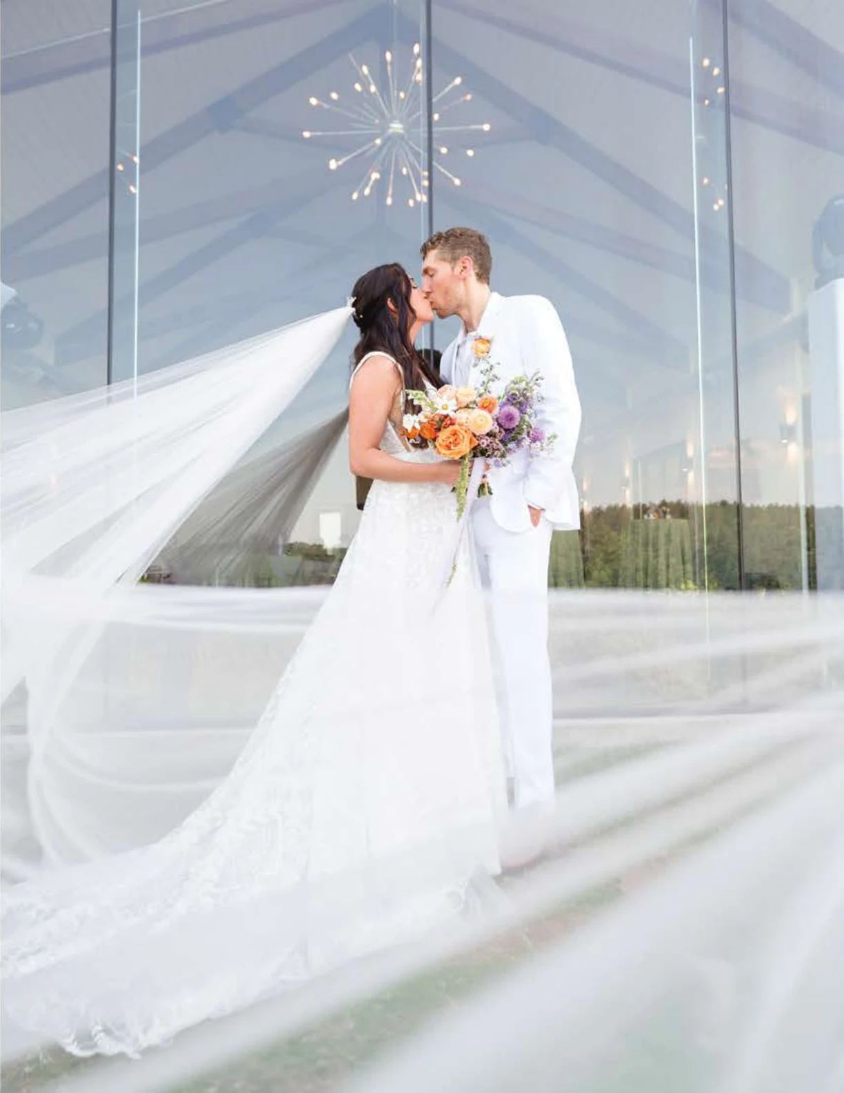 Bride and groom in front of a glass venue
